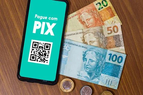 Pix on smartphone screen with multiple coins around. Pix is the new payment a Stock Photos