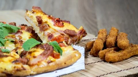 Pizza and the fried nuggets Placed in a pad made of wood Prepare for this din Stock Photos