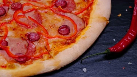 Pizza with bacon and sausage close up on black background Stock Footage 166524482