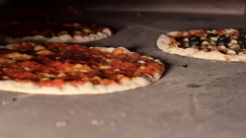 Pizza baking cooking in fast rotating wood oven Stock Footage 131871669