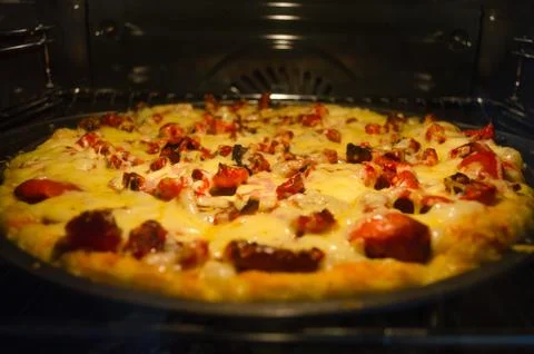 Pizza baking in oven Stock Photos
