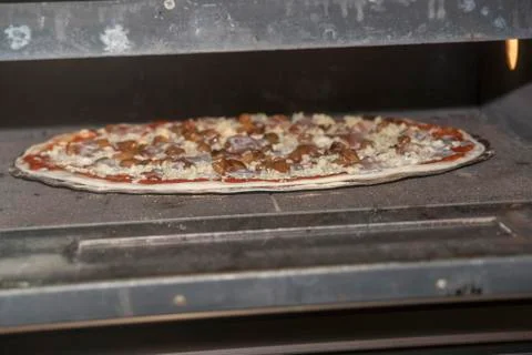 Pizza baking in the oven Stock Photos