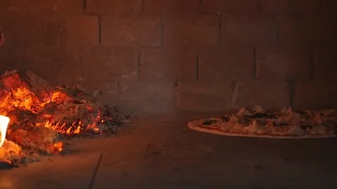 Pizza baking in a wood fired oven Stock Footage