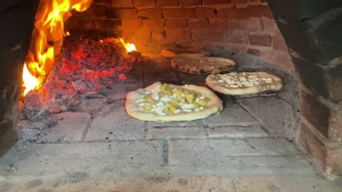 Pizza being cooked in an artisan oven, with a lit fire Stock Footage 156655953