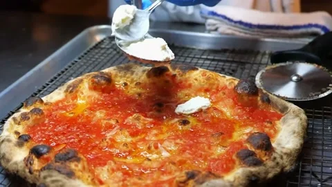 The pizza is being finished. The chef is putting cheese on the pizza Stock Footage 171736782