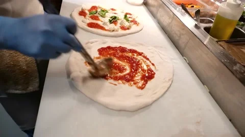 The pizza is being finished. the chef is putting ketchup on the pizza Stock Footage 171736797