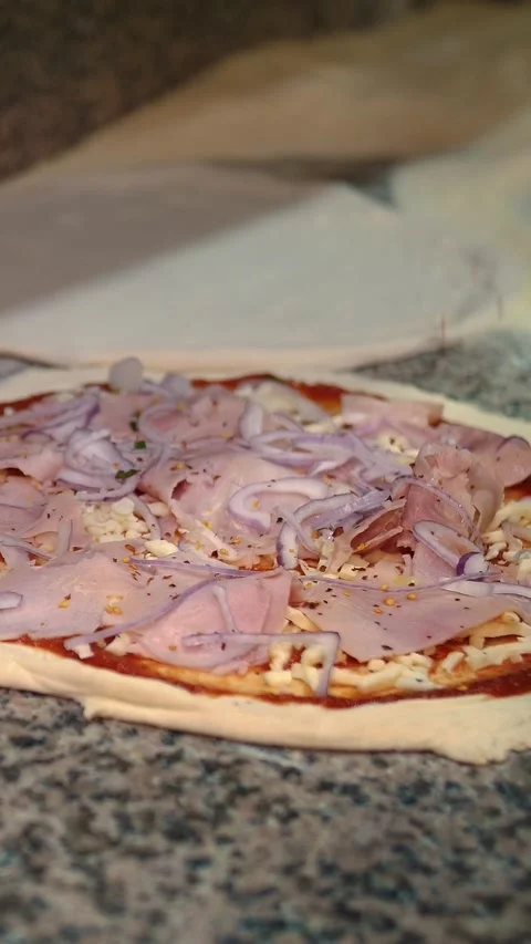 Pizza being prepared in the restaurant kitchen. The chef sprinkles Italian pizza Stock Footage 315093128