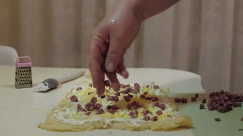 Pizza being sprinkled with toppings on a kitchen counter Vidéo 342362953