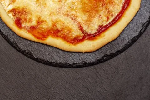 Pizza on a black table. Side view. Homemade tasty little pizza Fotos de archivo