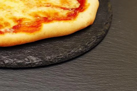 Pizza on a black table. Side view. Homemade tasty little pizza Fotos de archivo