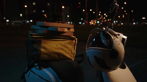 Pizza boxes are lying on a scooter against the background of the evening city Stock Footage 265063083