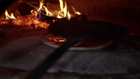 A pizza called "margherita" is pulled out of the wood oven. Traditional Italian Stock Footage 83544538