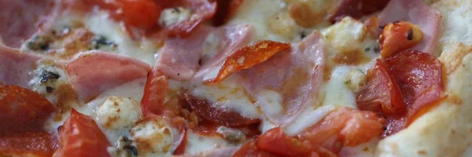 Pizza with cheese, ham, sausage, spices and tomato sauce closeup Stock Photos
