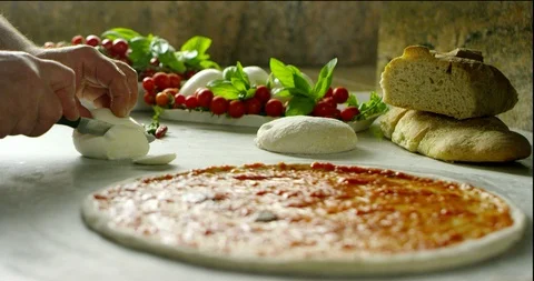 Pizza chef cutting a buffalo mozzarella to put it on the pizza 4k Stock Footage 87399347