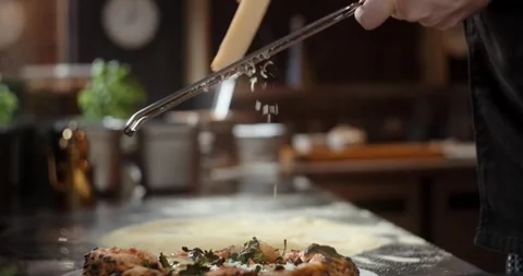 Pizza chef grates cheese to the pizza in restaurant Stock Footage 265431387