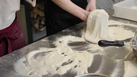 Pizza Chef makes the pizza dough spin in the air to make it thin and soft Stock Footage 232245774