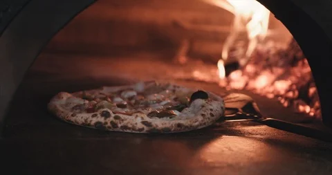 Pizza comes into focus while being cooked in a flame oven Stock Footage 105310299