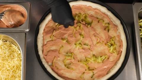 Pizza cooking pickled cucumbers fall on the dough with sauce Stock Footage 262874839