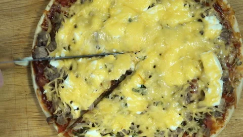 Pizza is cut with a knife in 4K Stock Footage 148096918