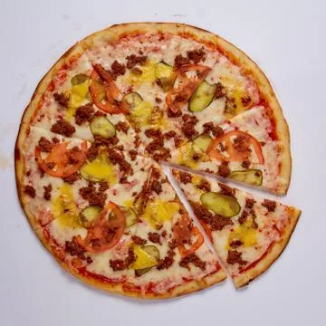Pizza with cut off slice on a white background. Top view. Stock Photos