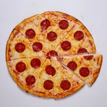 Pizza with cut off slice on a white background. Top view. Stock Photos
