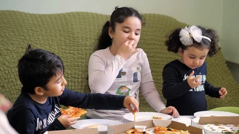 Pizza delivery. boy and two girls eating pizza and French fries Stock Footage 125691838