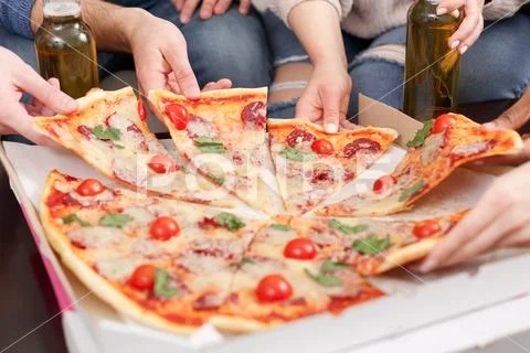Pizza delivery. Friends taking slices of delicious pizza Stock Photos