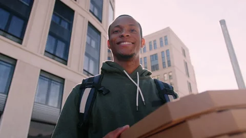 Pizza delivery man looks at the camera with a smile on a sunny day outside Stock Footage 222888482