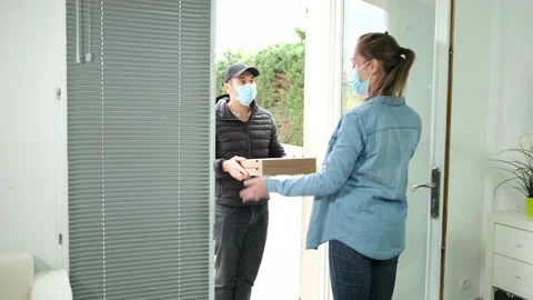 Pizza delivery man with mask and a beautiful woman at home during covid 19 Stock Footage