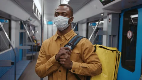 Pizza deliveryman with a backpack rides in a subway car. Face mask, pandemic Stock Footage 239322294