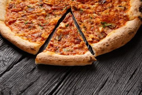 Pizza with different types of meat on black wooden background Stock Photos
