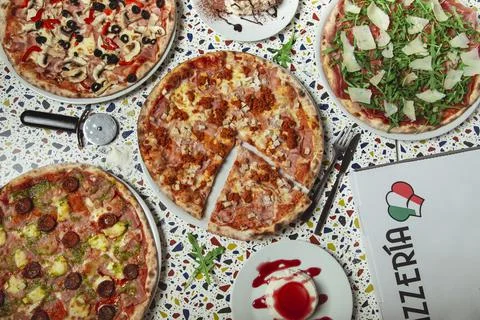 Pizza dinner. Flat lay of various types of Italian pizza and desserts on rest Stock Photos