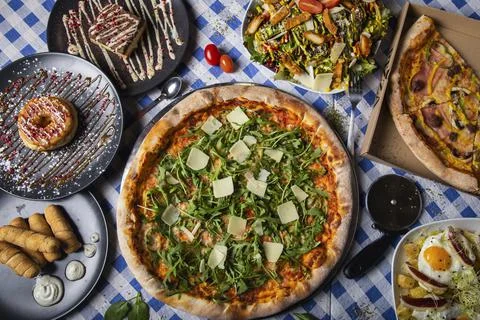 Pizza dinner. Flat lay of various types of Italian pizza and desserts on rest Stock Photos