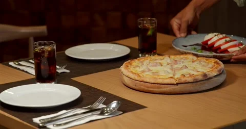 Pizza dinner table setting with drinks, plates, and utensils in Video stock 311998530