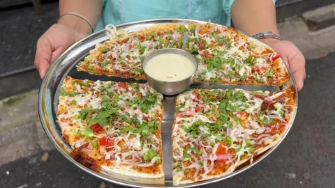 Pizza dosa, a fusion dish prepared in a south Indian restaurant in Kolkata Stock Footage 310285553