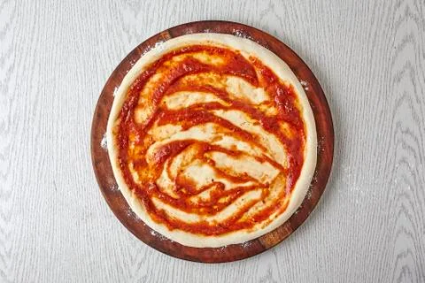 Pizza dough, 3rd step of spread the pizza dough with tomato sauce Stock Photos