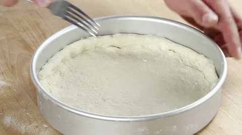 Pizza dough being pierced with a fork and brushed with olive oil Video stock 24672552