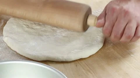 Pizza dough being rolled out and place in a deep pizza dish Video stock 24672546