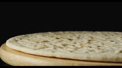 A pizza dough is rotating on a dark background Stock Footage 63509183