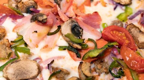 Pizza with ham, cherry tomatoes, pepper and champignon mushrooms. Close up. Stock Photos