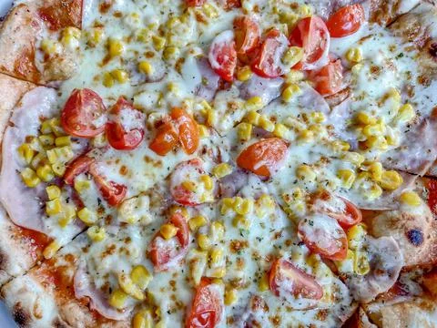 Pizza with ham, mozzarella, corn and tomatoes Fotos Stock