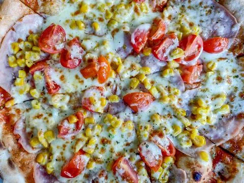 Pizza with ham, mozzarella, corn and tomatoes Stockfoto's