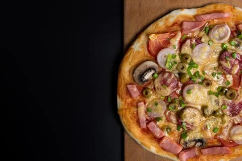 Pizza on kitchen board with copyspace. Stock Photos