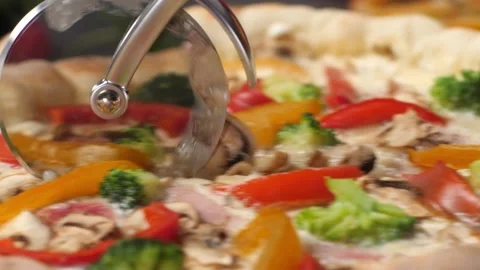 A pizza knife rolls over the surface of a fresh pizza, cutting it. Video stock 194379459