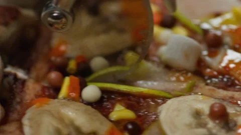 A pizza knife rolls over the surface of a fresh chocolate pizza, cutting it. Video stock 259826664