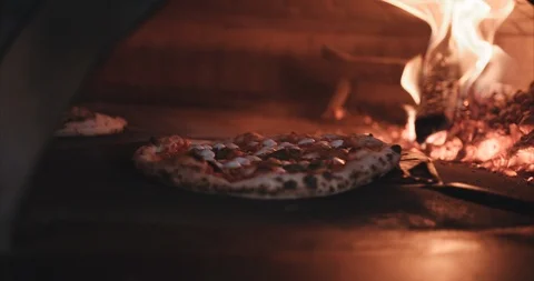 Pizza with leopard spots open flame brick oven Stock Footage 105310165