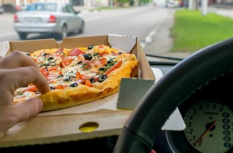 Pizza lies on the car panel Stock Photos