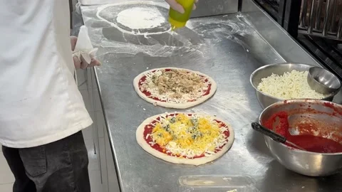 Pizza is made by fresh ingredient material and baked in a hot fire oven by Vidéo 229829482