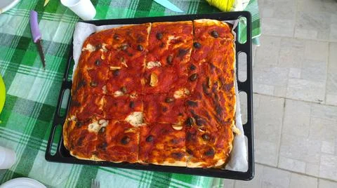 Pizza made at home on a baking sheet at home italian with sauce hand made Stock Photos