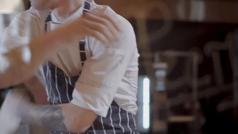 Pizza maker of handsome young man spinning and tossing pizza dough up. Slow Stock Footage 104854068